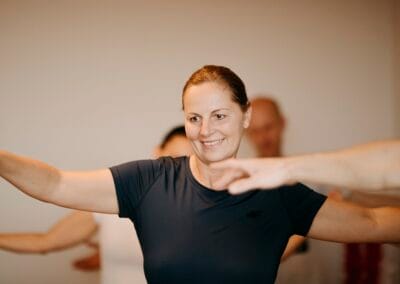 A woman in a black T-shirt is learning to do the hula dance..