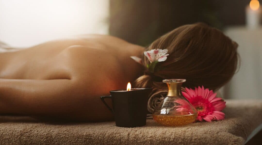 Klientka przed masażem Lomi Lomi, olejki, kwiaty, świeczka.